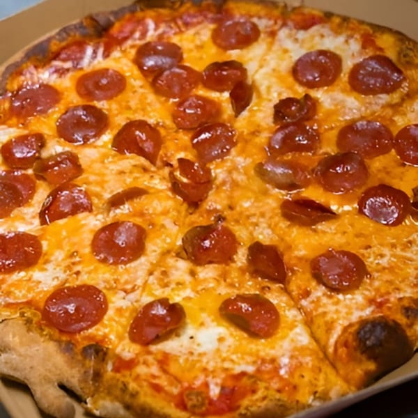 A close-up, overhead view of a freshly baked pepperoni pizza with melted cheese, sliced and ready to eat.